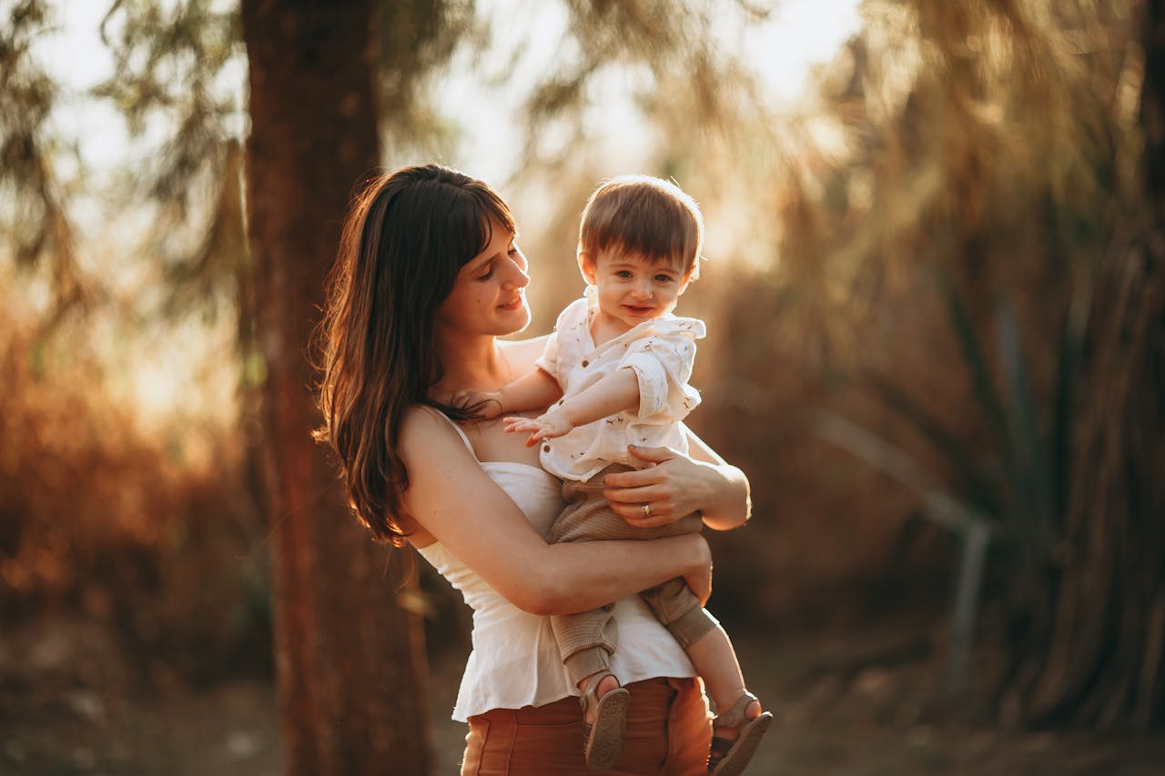 A woman holding a baby in her arms in the sun