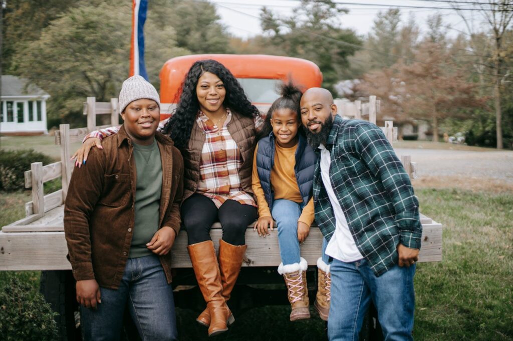 pexels-photo-5727785 Cheerful African American family embracing near vehicle on farm